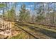 The home's backyard features mature trees for privacy, with a wooden deck and stairs at 1107 Goldendale Dr, Durham, NC 27703