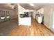 Open kitchen layout with hardwood floors, white cabinets, and views into a carpeted living area at 1107 Goldendale Dr, Durham, NC 27703