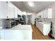 Well-lit kitchen featuring white cabinets, stainless steel appliances, hardwood floors, and ample counter space at 1107 Goldendale Dr, Durham, NC 27703