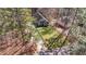 A serene aerial view of home nestled in a wooded lot with a fenced-in backyard and lush green grass at 113 Pony Dr, Louisburg, NC 27549