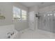 Bright bathroom featuring tiled floors, a bathtub, and a walk-in shower at 113 Pony Dr, Louisburg, NC 27549