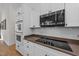 Modern kitchen features a built-in oven, microwave, and cooktop, with sleek white cabinets at 113 Pony Dr, Louisburg, NC 27549