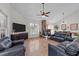 Cozy living room boasts hardwood floors, a stone fireplace and modern ceiling fan at 113 Pony Dr, Louisburg, NC 27549