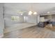 Open-concept living room with a cozy fireplace, wood floors, and a chandelier lighting fixture at 11771 Raleigh Rd, Four Oaks, NC 27524
