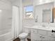 Bright bathroom featuring vanity with drawers, dark floors, tub and window at 141 N District Ave # 295, Clayton, NC 27527