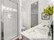 Bright bathroom featuring double sinks with a glass enclosed walk-in shower and a view into the walk in closet at 141 N District Ave # 295, Clayton, NC 27527