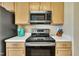 Kitchen with stainless steel microwave and range with light wood cabinets at 1968 Shadow Glen Dr, Raleigh, NC 27604