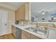 Kitchen sink with stainless steel dishwasher and view into the living room at 1968 Shadow Glen Dr, Raleigh, NC 27604