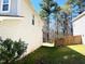 A small patch of the sideyard next to the house and a wooden fence at 204 Hillview Dr, Durham, NC 27703