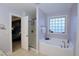 Bathroom featuring tub with shower, tiled floors, and a window to provide natural light at 2144 Waterview Dr, Graham, NC 27253