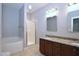 Well-lit bathroom featuring double sinks with granite countertop, tub, and glass enclosed shower at 2144 Waterview Dr, Graham, NC 27253