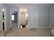 Hallway with neutral carpet, access to rooms, and a view of the staircase at 2144 Waterview Dr, Graham, NC 27253