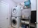Laundry room featuring stacked washer/dryer, utility sink, and storage at 2144 Waterview Dr, Graham, NC 27253