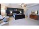 Bright main bedroom featuring tray ceiling, ceiling fan, and furniture at 2144 Waterview Dr, Graham, NC 27253