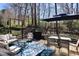 Inviting patio with outdoor seating, a shade umbrella, and a view of the treed backyard at 2144 Waterview Dr, Graham, NC 27253