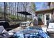 Comfortable patio with dining and lounging areas, shaded by trees, and overlooking the backyard at 2144 Waterview Dr, Graham, NC 27253