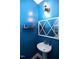 Stylish powder room featuring bright blue walls, a pedestal sink, and modern lighting at 2144 Waterview Dr, Graham, NC 27253