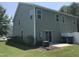 View of the back exterior with vinyl siding, a sliding glass door, and a small patio area at 2306 Stoney Spring Dr, Raleigh, NC 27610
