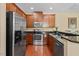 Contemporary kitchen with stainless steel appliances, dark cabinets, and an open layout, perfect for cooking and entertaining at 2306 Stoney Spring Dr, Raleigh, NC 27610