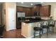 Modern kitchen featuring dark wood cabinets, stainless steel appliances, and a breakfast bar, perfect for casual dining at 2306 Stoney Spring Dr, Raleigh, NC 27610