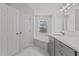 Bright bathroom featuring a soaking tub and modern vanity with grey cabinetry and white countertop at 2613 Coxindale Dr, Raleigh, NC 27615