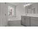 Bright bathroom featuring a soaking tub and a vanity with storage at 2613 Coxindale Dr, Raleigh, NC 27615