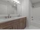 Bathroom featuring a dual sink vanity with wood cabinetry, a large mirror, and shower-tub combo at 2613 Coxindale Dr, Raleigh, NC 27615
