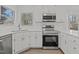 Bright kitchen features stainless steel appliances, white cabinets, and a stainless steel sink at 2613 Coxindale Dr, Raleigh, NC 27615