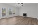 Bright living room features hardwood floors, a fireplace, a ceiling fan, and large windows at 2613 Coxindale Dr, Raleigh, NC 27615