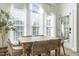 Elegant dining room with a rustic wooden table and woven chairs under large bright windows at 2720 Stratford Hall Dr, Raleigh, NC 27614