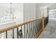 An indoor landing with a wooden bannister, metal pickets, white trim, a window, and a carpeted floor at 2720 Stratford Hall Dr, Raleigh, NC 27614