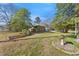 A single-story brick home on a spacious lot with mature trees and charming landscaping at 2911 Broad St, Durham, NC 27704