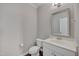 Powder room features a white vanity and commode with silver mirror at 300 Mariah Towns Way, Garner, NC 27529