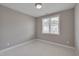 Neutral bedroom with a large window providing natural light and neutral carpet and walls at 300 Mariah Towns Way, Garner, NC 27529