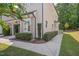 Corner view of the townhome featuring manicured landscaping, covered entry, and sidewalk at 300 Mariah Towns Way, Garner, NC 27529