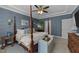 Spacious bedroom with four-poster bed, blue walls, tray ceiling, and ample natural light at 308 Masden Rd, Holly Springs, NC 27540