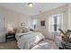 Stylish bedroom featuring a plush bed, decorative wall paneling, and natural light at 308 Masden Rd, Holly Springs, NC 27540