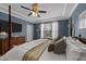 Bedroom with four-poster bed, blue textured walls, tray ceiling, and window at 308 Masden Rd, Holly Springs, NC 27540