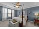 Bedroom with four-poster bed, blue walls, tray ceiling, and view of the window at 308 Masden Rd, Holly Springs, NC 27540