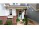 Inviting front porch with a blue door, brick accents, a hanging light fixture and green shrubs at 308 Masden Rd, Holly Springs, NC 27540