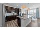 Modern kitchen features dark cabinets, granite countertops, stainless steel appliances, and an island with pendant lighting at 308 Masden Rd, Holly Springs, NC 27540
