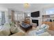 Bright and airy living room featuring a fireplace, built-in shelves, and comfortable seating arrangements at 308 Masden Rd, Holly Springs, NC 27540