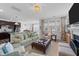 Cozy living room with fireplace, plush seating, and an open layout to kitchen and dining area at 308 Masden Rd, Holly Springs, NC 27540