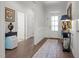Bright entryway with white trim, hardwood floors, and decorative front door with glass panes at 310 Macallan, Burlington, NC 27215