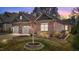 Home exterior featuring a two-car garage and stone-lined garden bed under a twilight sky at 310 Macallan, Burlington, NC 27215