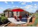 Enjoy outdoor gatherings on this brick patio with table and red umbrella at 310 Macallan, Burlington, NC 27215