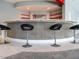 Contemporary bar area featuring four black bar stools, modern lighting, shelving, and plush carpeting at 314 Montelena Pl, Cary, NC 27513