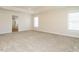 Large bedroom featuring neutral walls, plush carpet, and an entrance to an en-suite bathroom at 314 Montelena Pl, Cary, NC 27513
