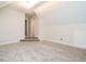 Neutral-toned bonus room with plush carpeting and view of hallway through a doorway and a small set of carpeted stairs at 314 Montelena Pl, Cary, NC 27513