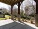 Covered patio with brick pillars, lush landscaping, and outdoor seating area at 314 Montelena Pl, Cary, NC 27513